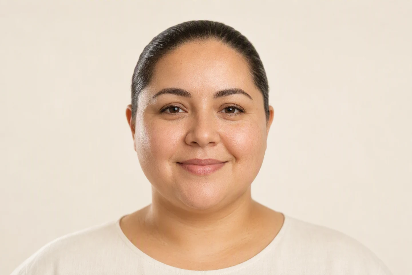 Front-facing portrait of a woman with a round face shape, full cheeks and a soft jawline